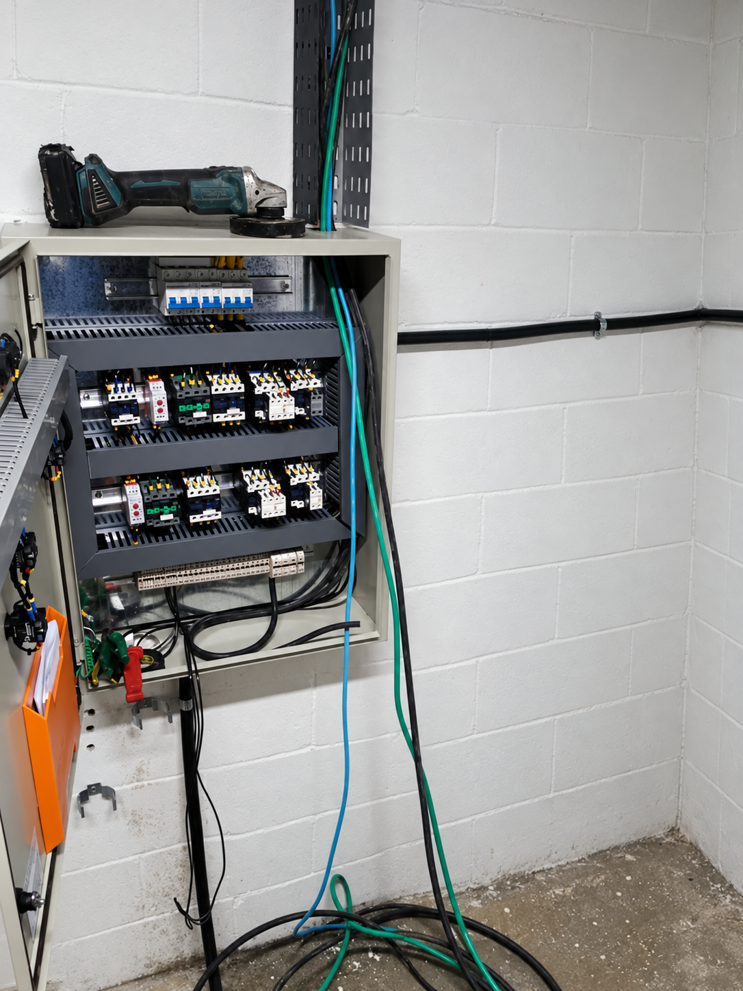 Quadro elétrico com componentes e cabeamento, em foto editada por IA para remover a pessoa